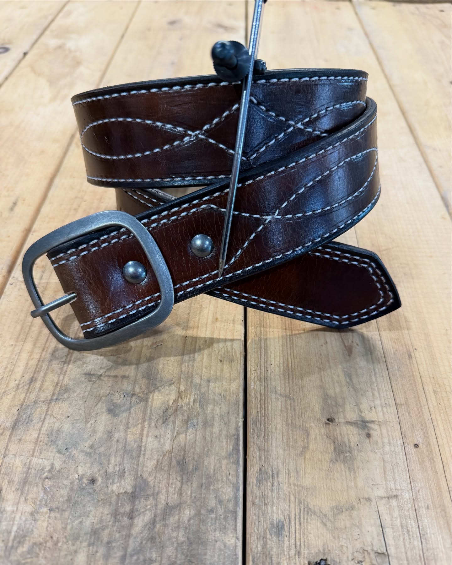 Dark leather belt with gunslinger cross-stitch and gunmetal hardware