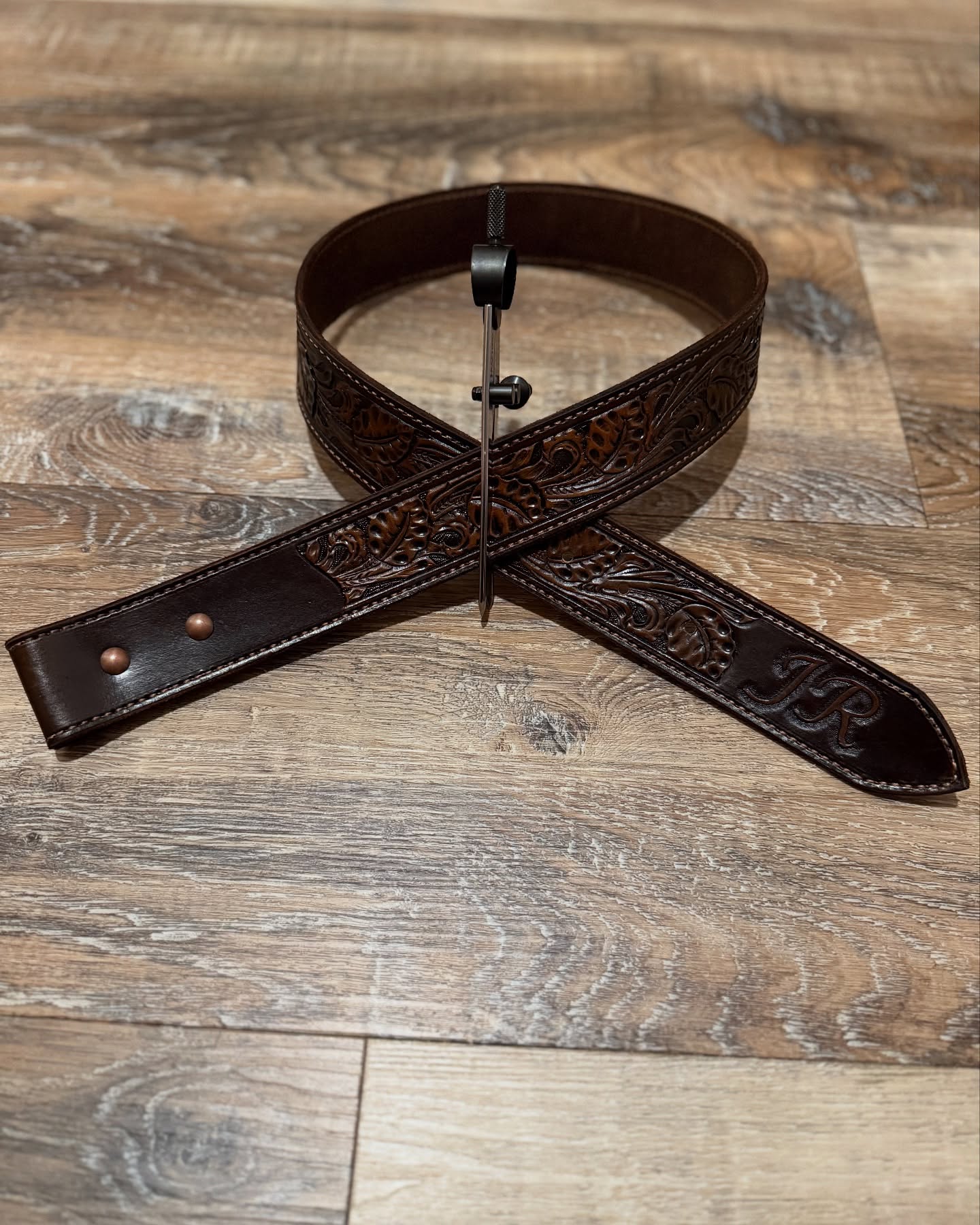 Hand tooled leather belt with scroll and vine pattern, dark brown